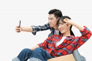 青年男女搬运纸箱拍照